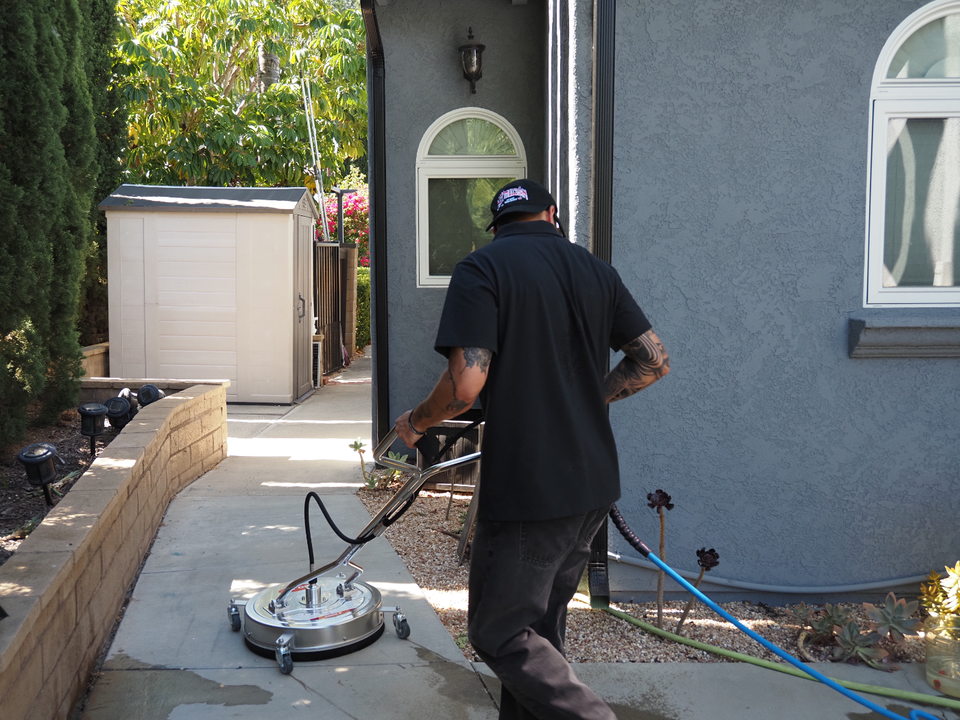 Dylan running a surface cleaner along a community walkway