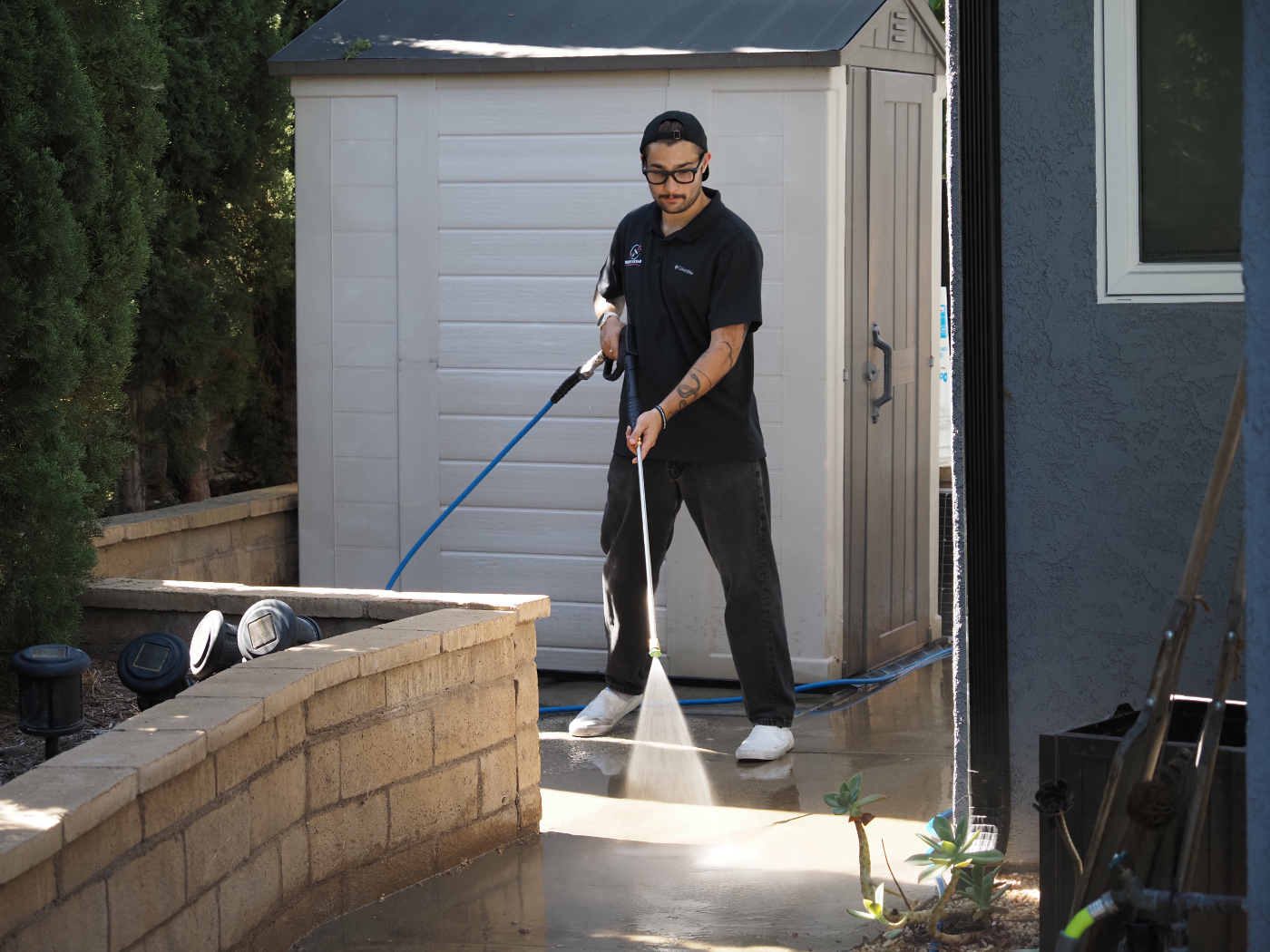 Dylan pressure washing a walkway with the wand